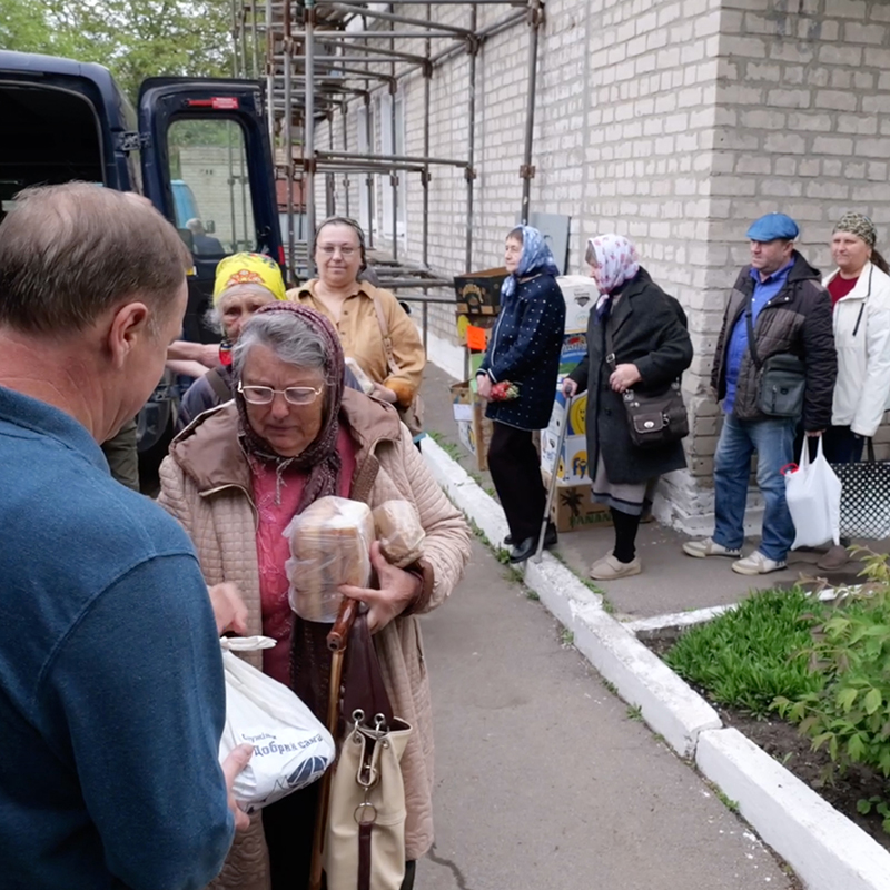 A line of people receiving aid
